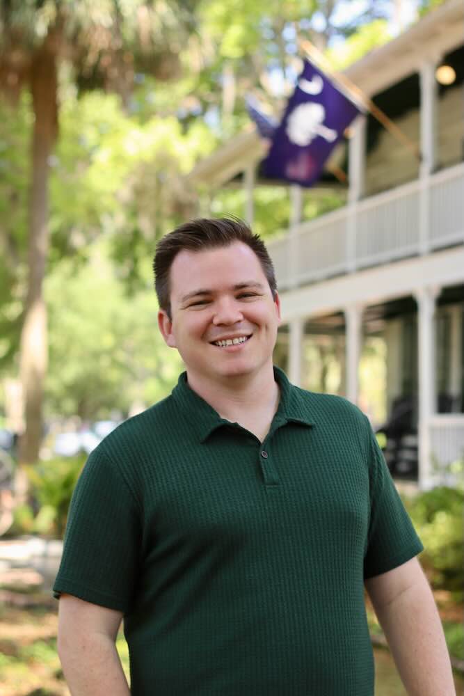 Smiling man in green polo outdoors