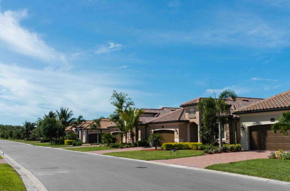 Suburban street with Mediterranean-style homes and palm trees
