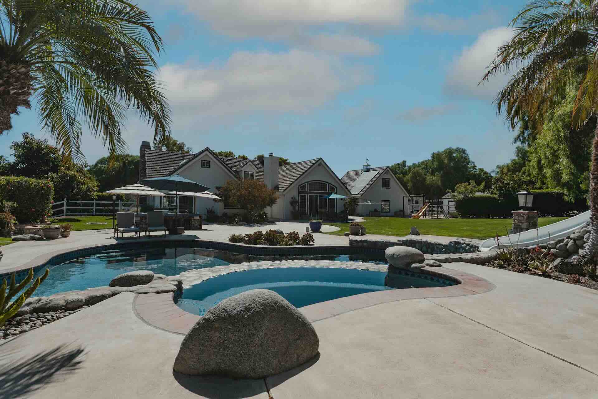 Luxury home backyard with pool and palm trees